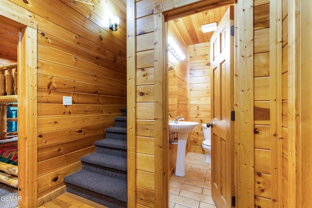 stairs featuring wooden walls and wooden ceiling