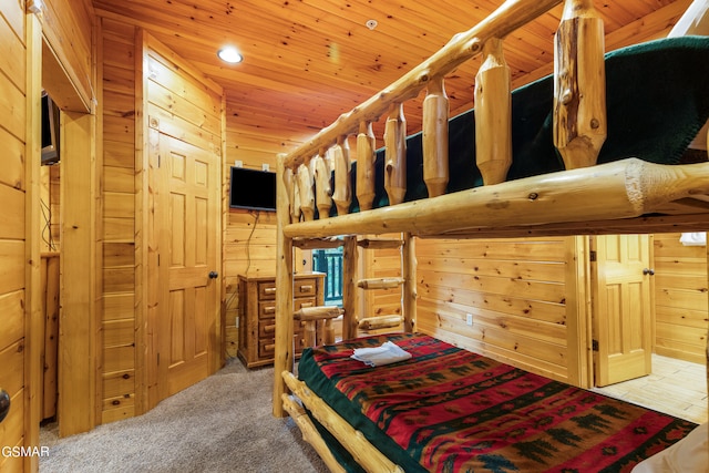 carpeted bedroom with wooden walls and wood ceiling