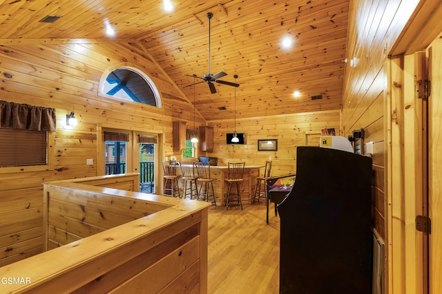 kitchen featuring hanging light fixtures, wooden walls, light hardwood / wood-style flooring, ceiling fan, and wood ceiling