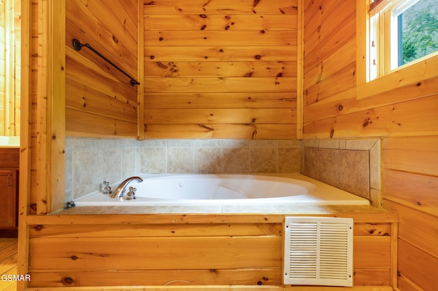 bathroom featuring wooden walls and a washtub