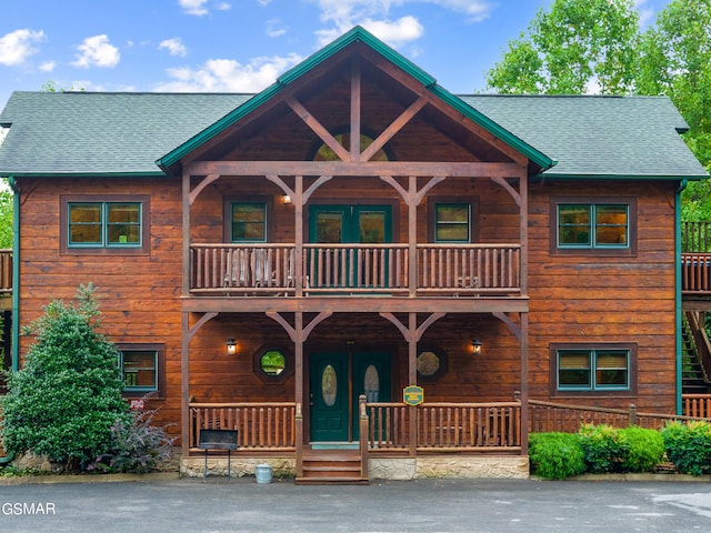 log-style house featuring a balcony and a porch