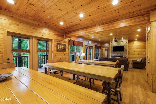 dining area with hardwood / wood-style floors, ceiling fan, wood ceiling, and a fireplace