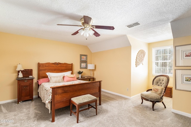 bedroom with ceiling fan, a textured ceiling, light colored carpet, visible vents, and baseboards