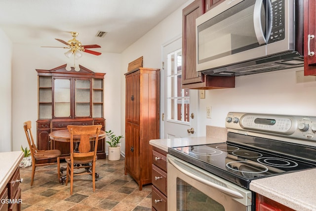 kitchen with stone finish flooring, light countertops, visible vents, ceiling fan, and stainless steel appliances