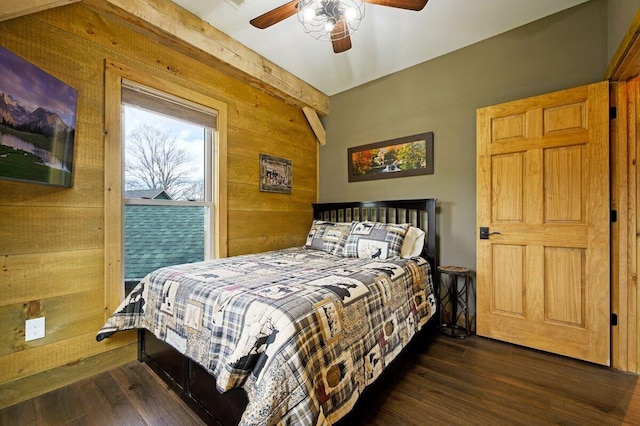 bedroom with dark hardwood / wood-style flooring, wooden walls, and ceiling fan