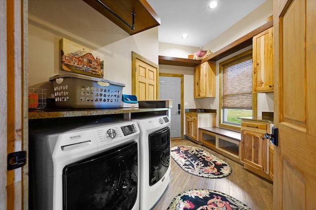 washroom with separate washer and dryer, cabinets, and hardwood / wood-style flooring