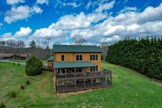 back of house with a lawn and a deck