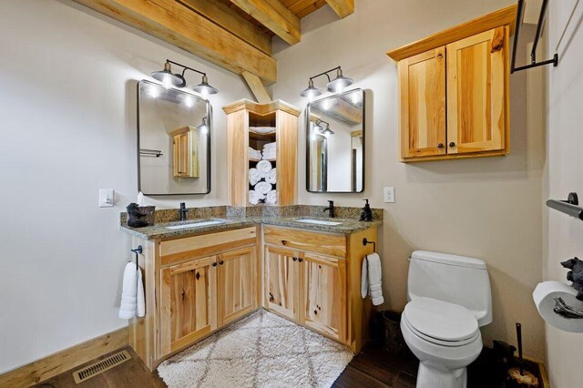 bathroom with vanity, hardwood / wood-style floors, beamed ceiling, and toilet