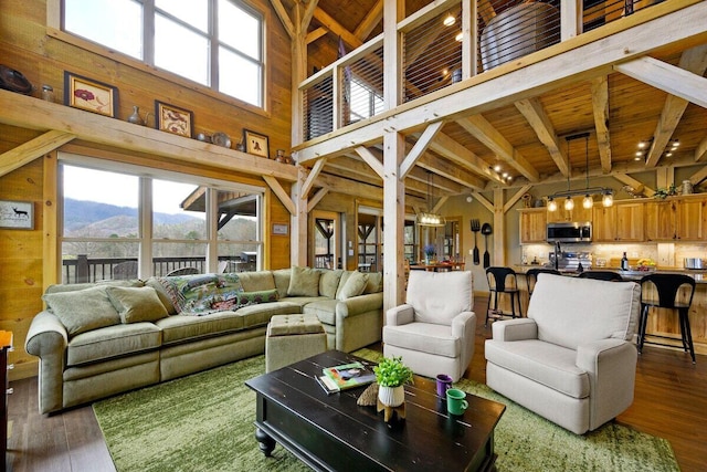 living room with wooden ceiling, a mountain view, dark hardwood / wood-style floors, a notable chandelier, and beam ceiling