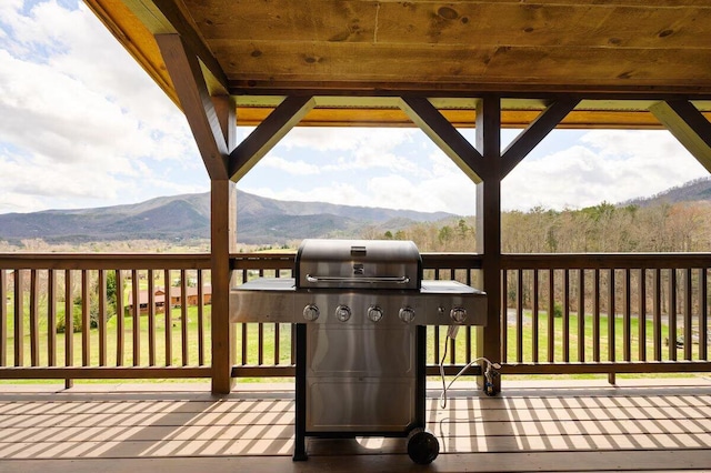 wooden terrace with a grill and a mountain view