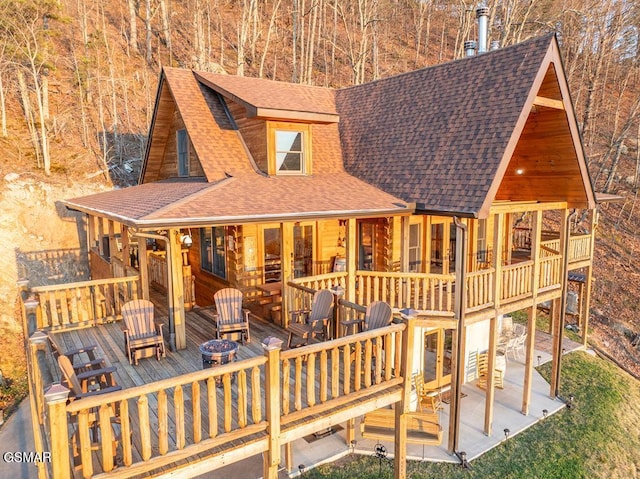 rear view of property with a patio area, a deck, and a fire pit