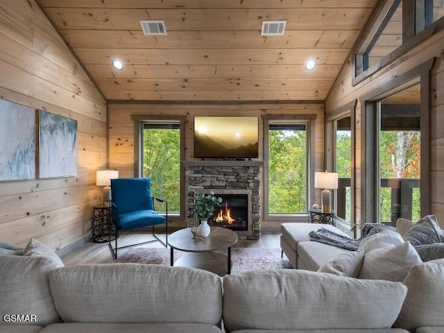 2434 Breezy Rd, Sevierville, TN 37876 - living room with vaulted ceiling, wooden ceiling, wood finished floors, wooden walls, and an outdoor stone fireplace