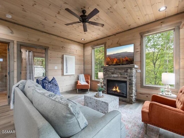 2434 Breezy Rd, Sevierville, TN 37876 - living area featuring wood ceiling, wood finished floors, healthy amount of natural light, ceiling fan, and a stone fireplace