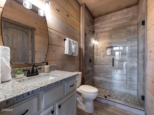 2434 Breezy Rd, Sevierville, TN 37876 - bathroom featuring wood walls, vanity, a shower stall, toilet, and wood finished floors
