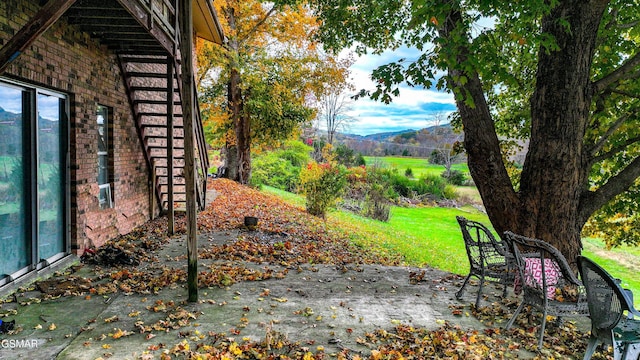 view of yard with a mountain view and a patio area