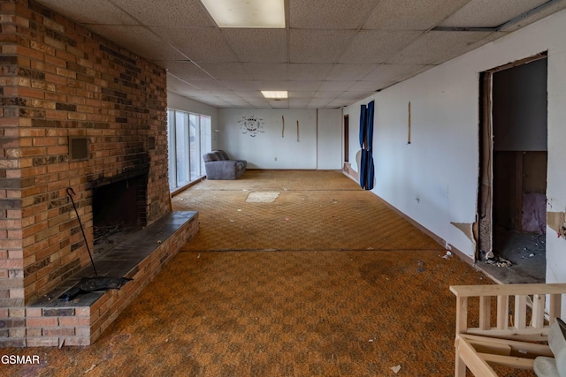 basement featuring a brick fireplace and a drop ceiling