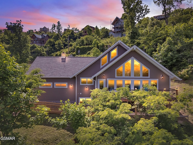 730 Deerfoot Dr, Gatlinburg, TN 37738 - back of property at dusk featuring a chimney, a shingled roof, and a wooden deck