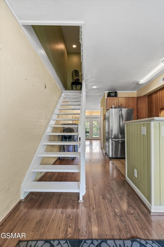 stairway featuring wood finished floors and french doors