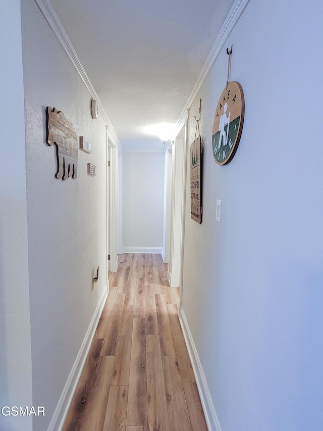 corridor featuring ornamental molding and light wood-type flooring