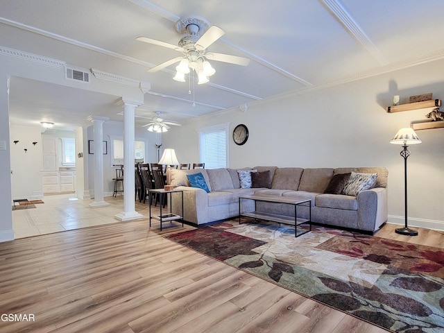 living room featuring ornate columns, ornamental molding, and light hardwood / wood-style floors