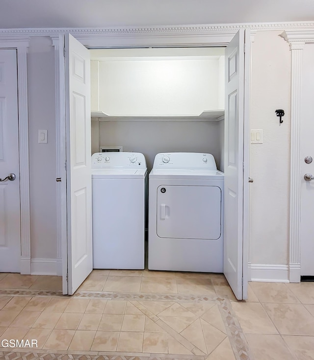 laundry area featuring light tile patterned floors and washing machine and dryer