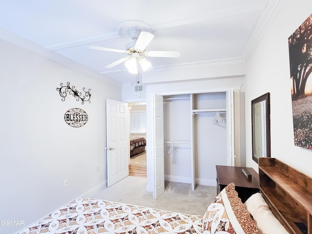 bedroom featuring ornamental molding, light colored carpet, a closet, and ceiling fan