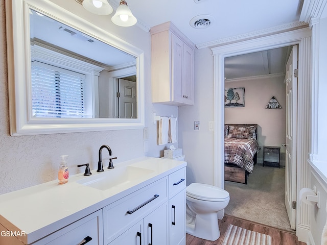 bathroom featuring crown molding, wood-type flooring, vanity, and toilet