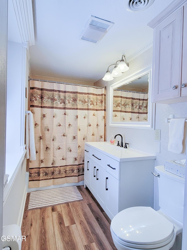 bathroom with hardwood / wood-style flooring, vanity, a shower with curtain, and toilet