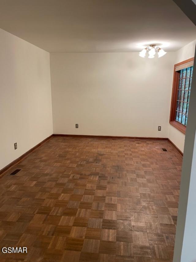 unfurnished room featuring dark parquet floors