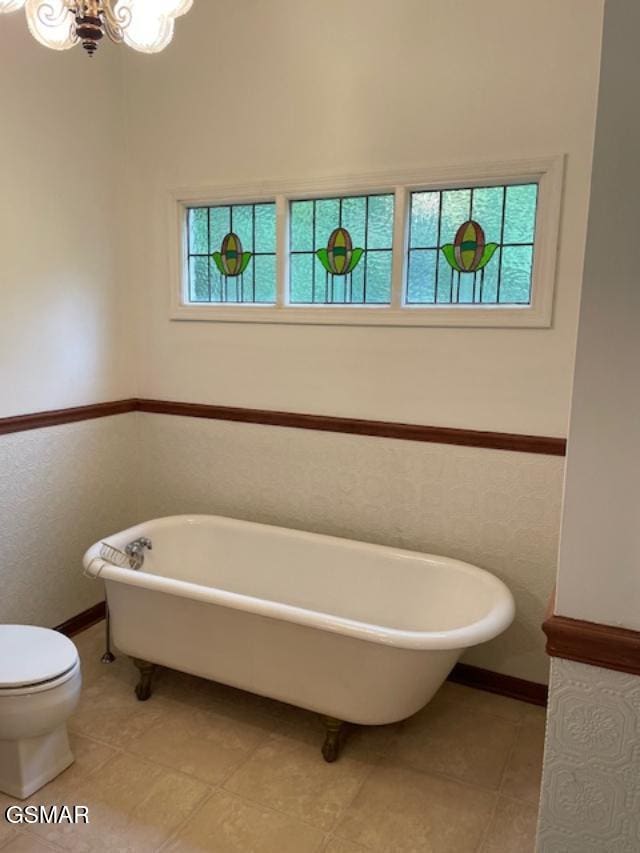 bathroom with toilet, tile patterned floors, and a tub