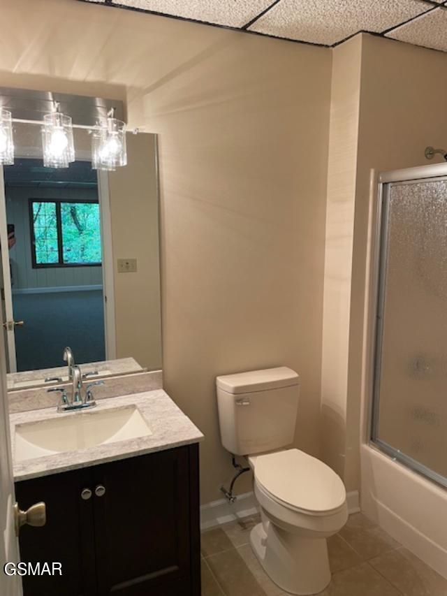 full bathroom with tile patterned flooring, vanity, toilet, and combined bath / shower with glass door