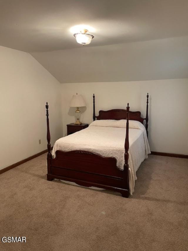 carpeted bedroom with lofted ceiling