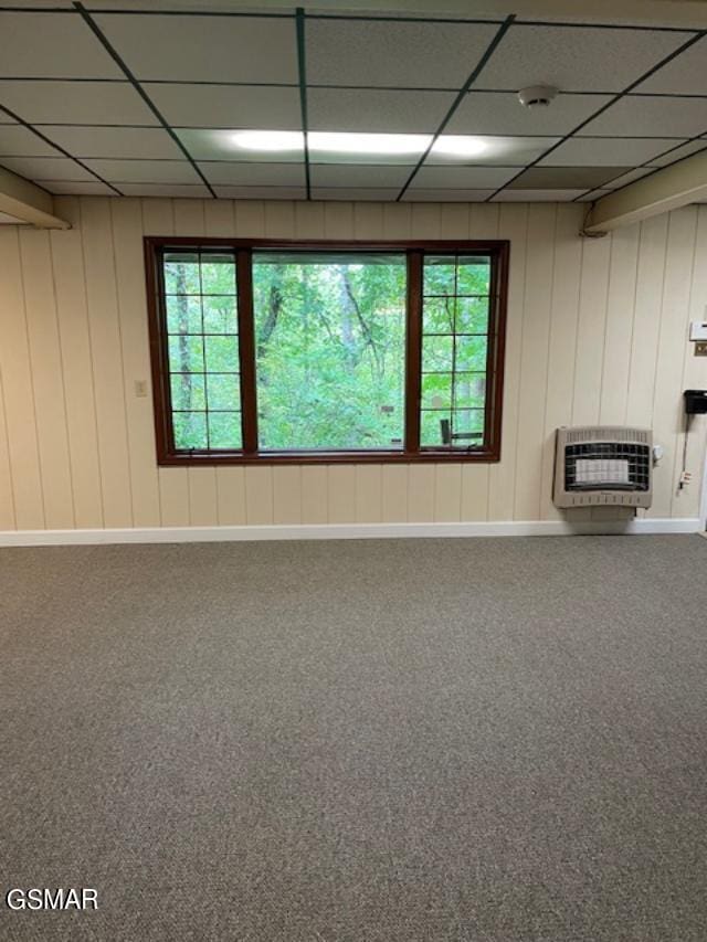 interior space featuring a paneled ceiling, heating unit, and plenty of natural light