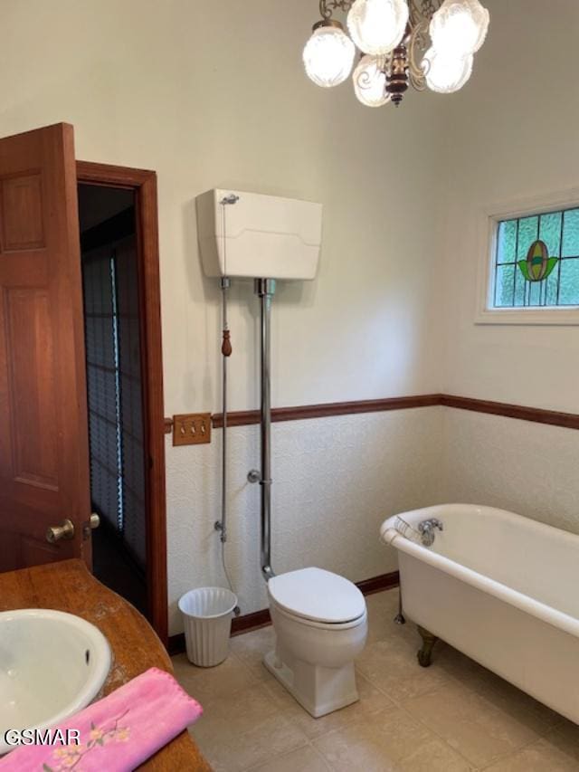 bathroom featuring toilet, a bathtub, a notable chandelier, and sink