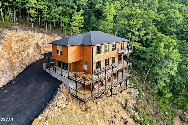 1990 Blackthorn Trl, Sevierville, TN 37876 - rear view of property featuring roof with shingles, asphalt driveway, a wooded view, and a deck
