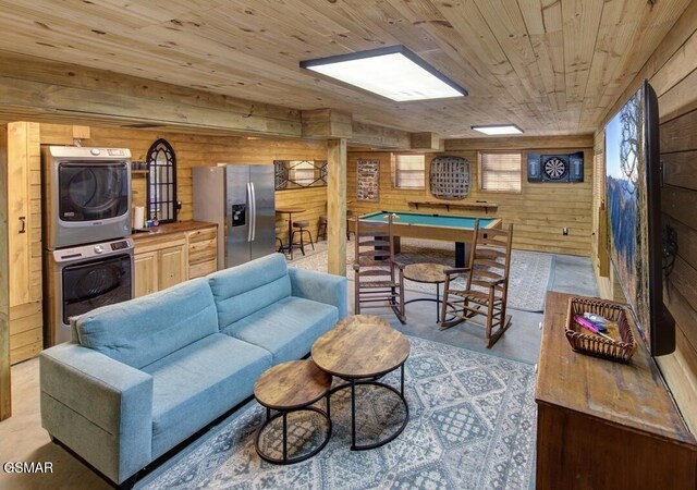 125 Cricket Hollow Way, Cosby, TN 37722 - living room featuring estacked washer and dryer, finished concrete flooring, wood walls, and wooden ceiling