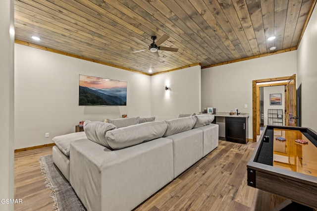 cinema room featuring hardwood / wood-style floors, crown molding, ceiling fan, and wooden ceiling