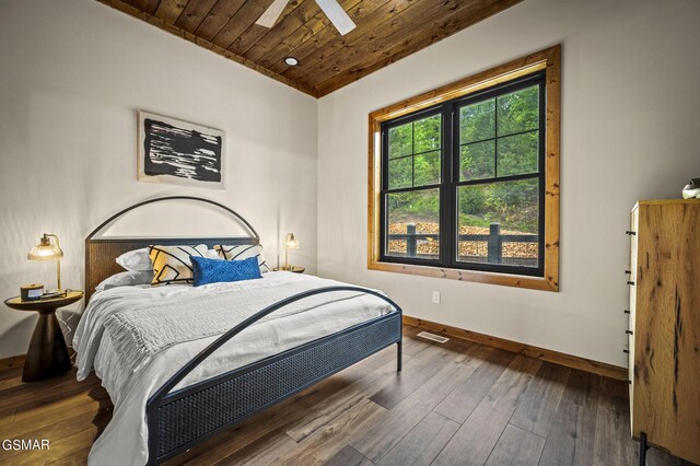 bedroom with dark wood-type flooring, vaulted ceiling, ceiling fan, and wooden ceiling