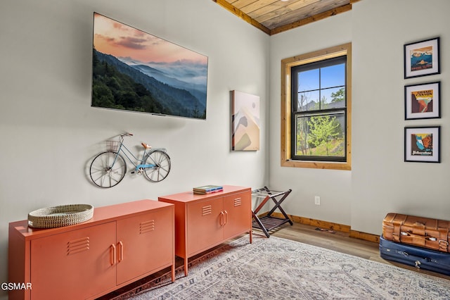 living area with hardwood / wood-style floors, wooden ceiling, and ornamental molding