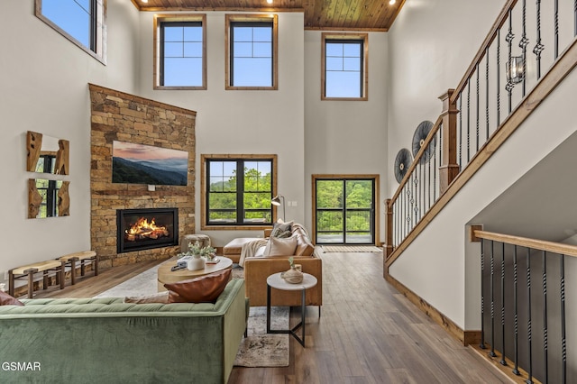 living room with hardwood / wood-style floors, a towering ceiling, and wooden ceiling