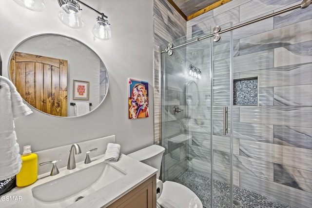 bathroom featuring vanity, toilet, and a shower with door