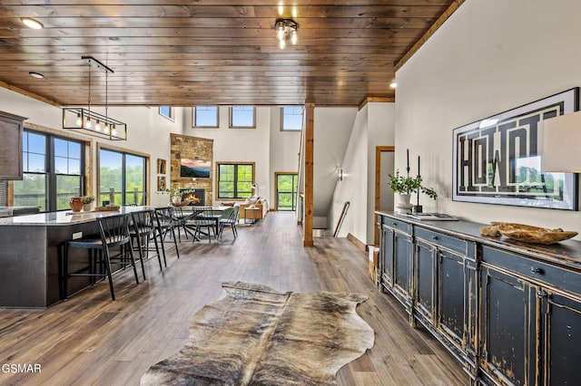 dining room featuring hardwood / wood-style floors, wood ceiling, and a fireplace