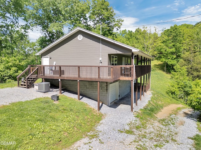 1668 Goodwater Rd, Bybee, TN 37713 - view of property exterior featuring a wooden deck, cooling unit, gravel driveway, and a yard
