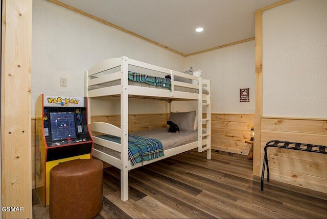 bedroom with crown molding, wood-type flooring, and wood walls