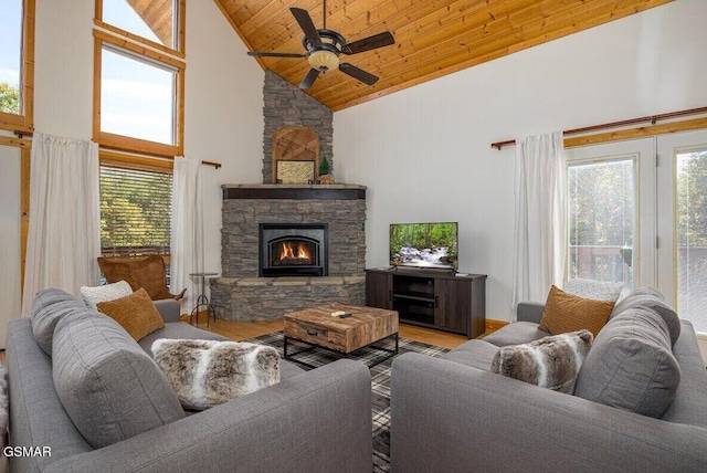 living room with high vaulted ceiling, a fireplace, ceiling fan, light hardwood / wood-style floors, and wooden ceiling