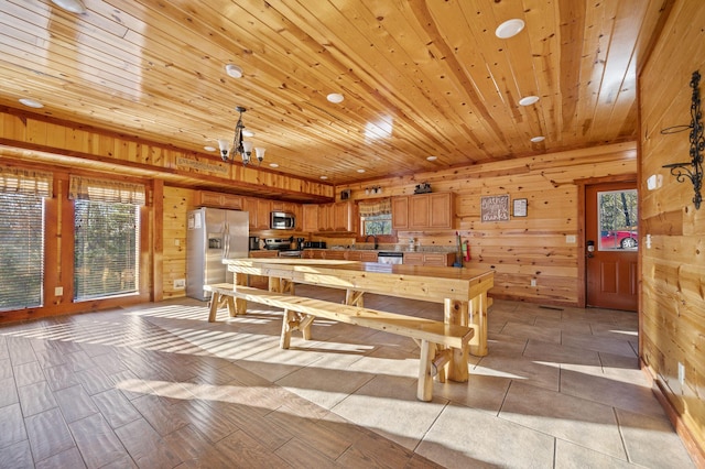 dining area with wood walls, wooden ceiling, and a notable chandelier