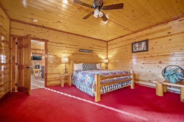 carpeted bedroom with ceiling fan, wooden walls, and wood ceiling