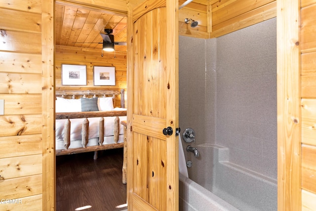 bathroom with wooden ceiling, wood walls, and  shower combination