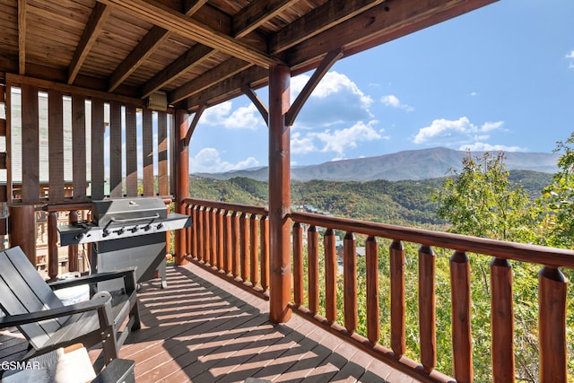 wooden deck featuring a mountain view and area for grilling