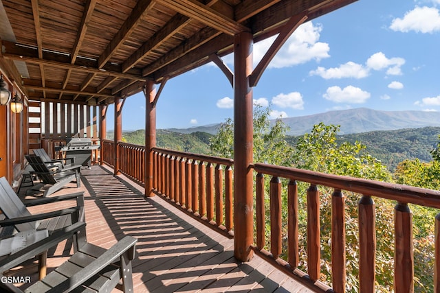 wooden deck with a mountain view and grilling area